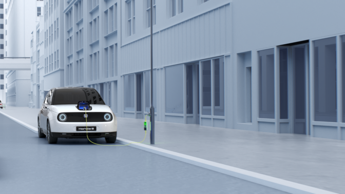 Vordere Seitenansicht des weißen Honda E Elektroautos auf simulierter Straße