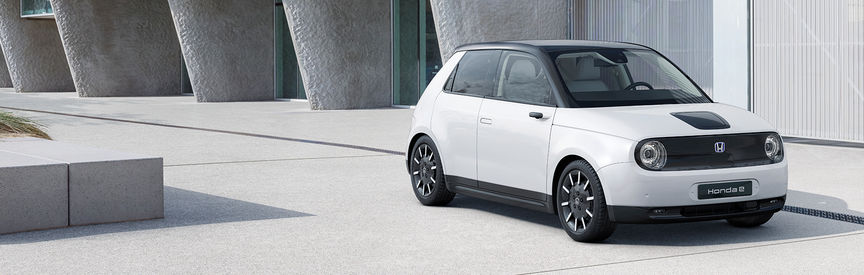 seitliche abgewinkelte Ansicht eines weißen Honda E Elektroautos