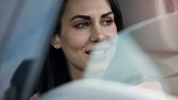 Fahrerin, die aus offenem Autofenster blickt, Nahaufnahme