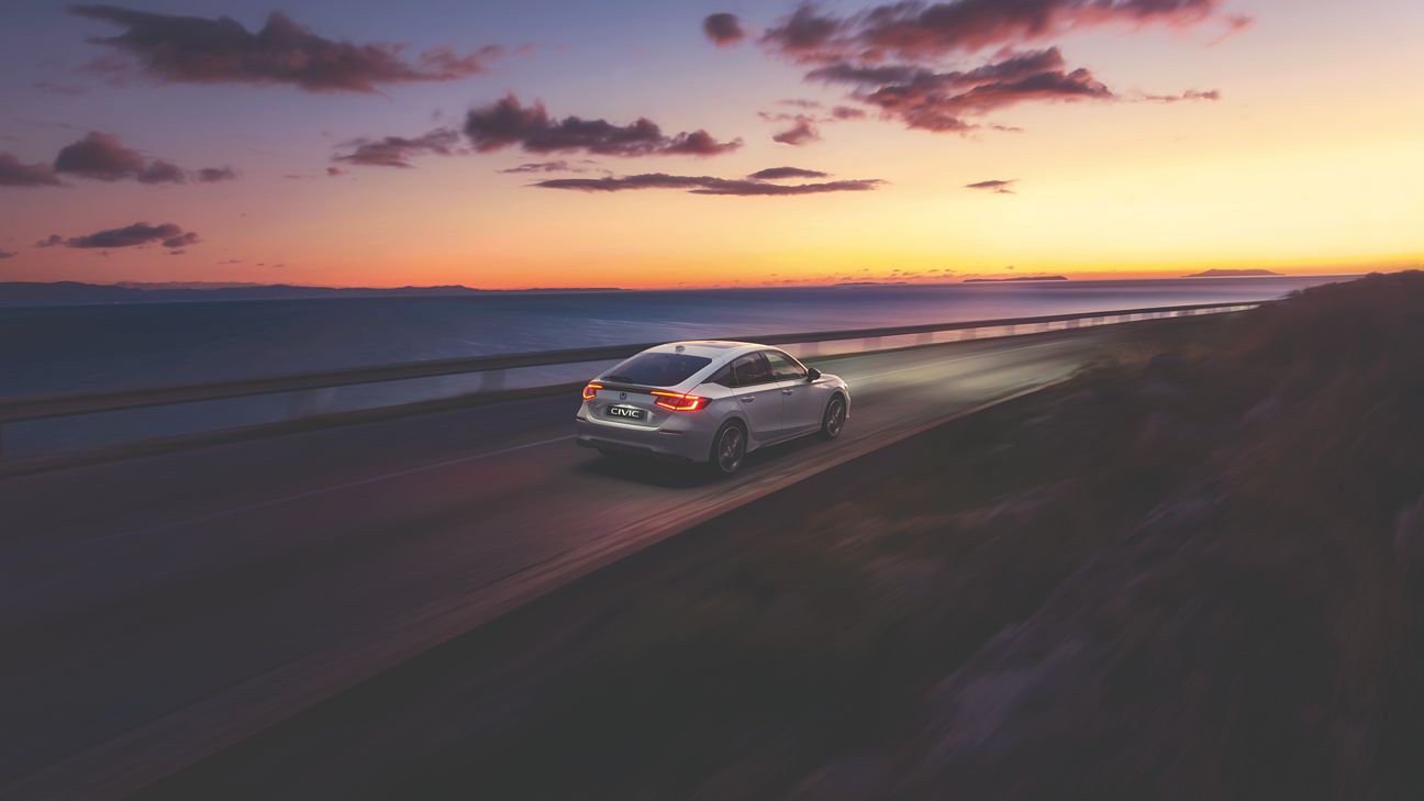 Ein weißer Honda Civic fährt bei Sonnenuntergang