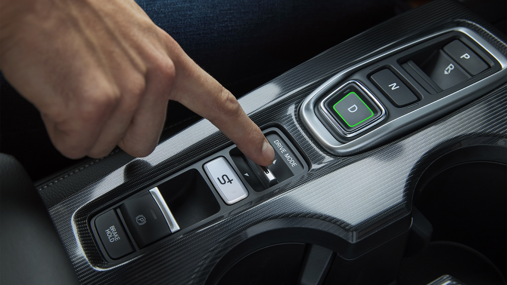 Nahaufnahme einer Person im Inneren des Civic Hybrid, die den Fahrmodus des Fahrzeugs einstellt.