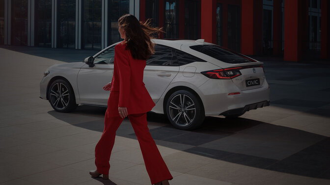 Dame geht auf einen Civic Hybrid zu