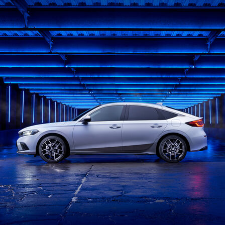 Seitenansicht eines in einer Seitenstraße geparkten Honda Civic e:HEV.