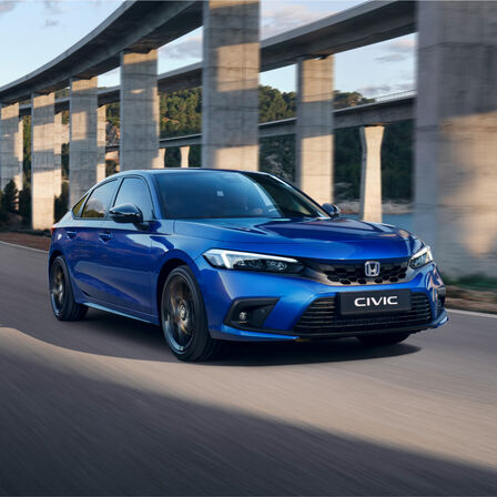 Honda Civic e:HEV, 3/4-Frontansicht auf einer Straße.