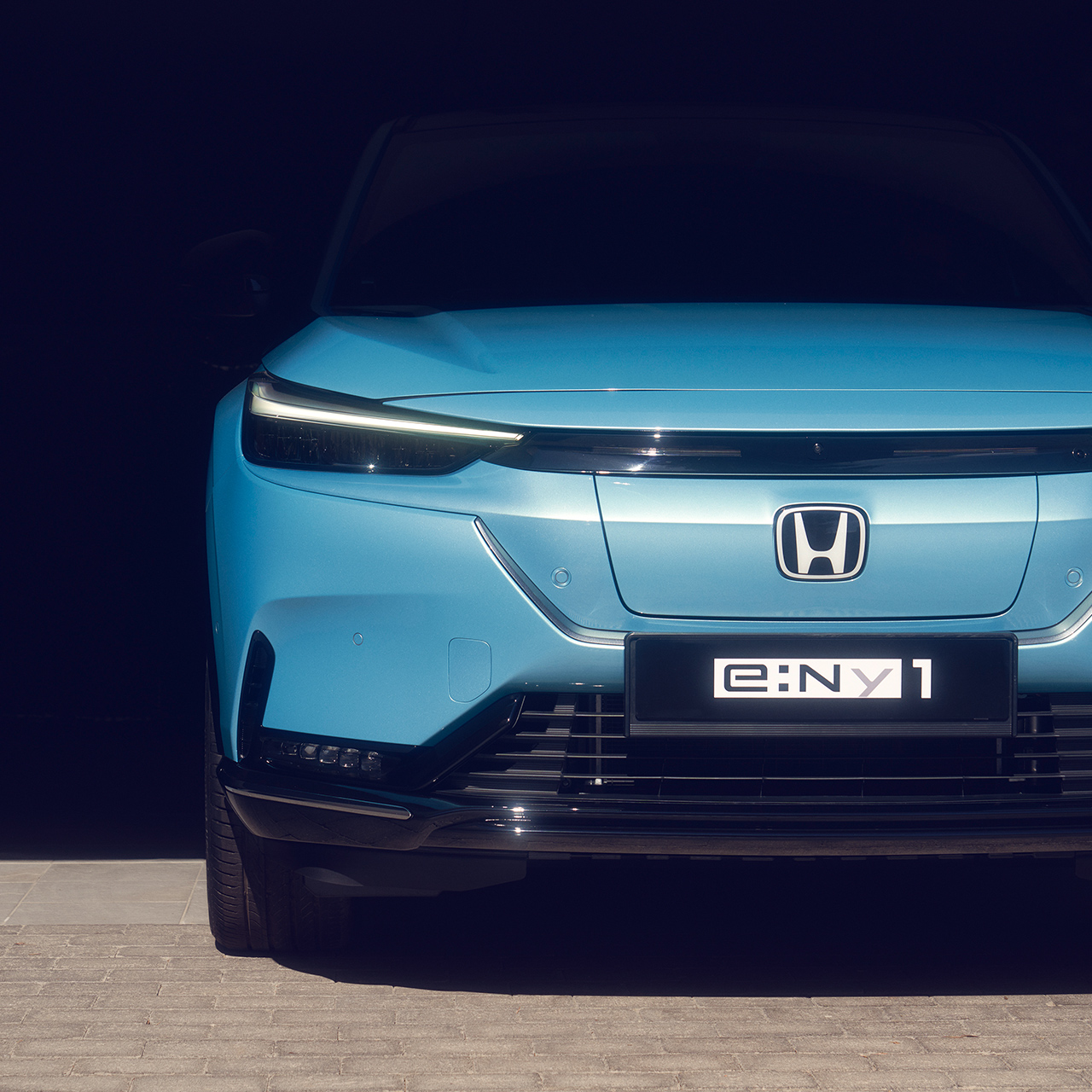 Nahaufnahme eines abgestellten Honda e:Ny1, Frontansicht.