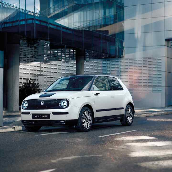 Honda e auf der Straße mit Gebäuden im Hintergrund