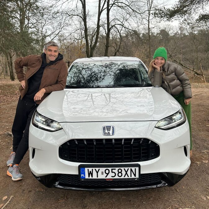 Zwei Influencer lehnen sich an den Honda ZR-V.