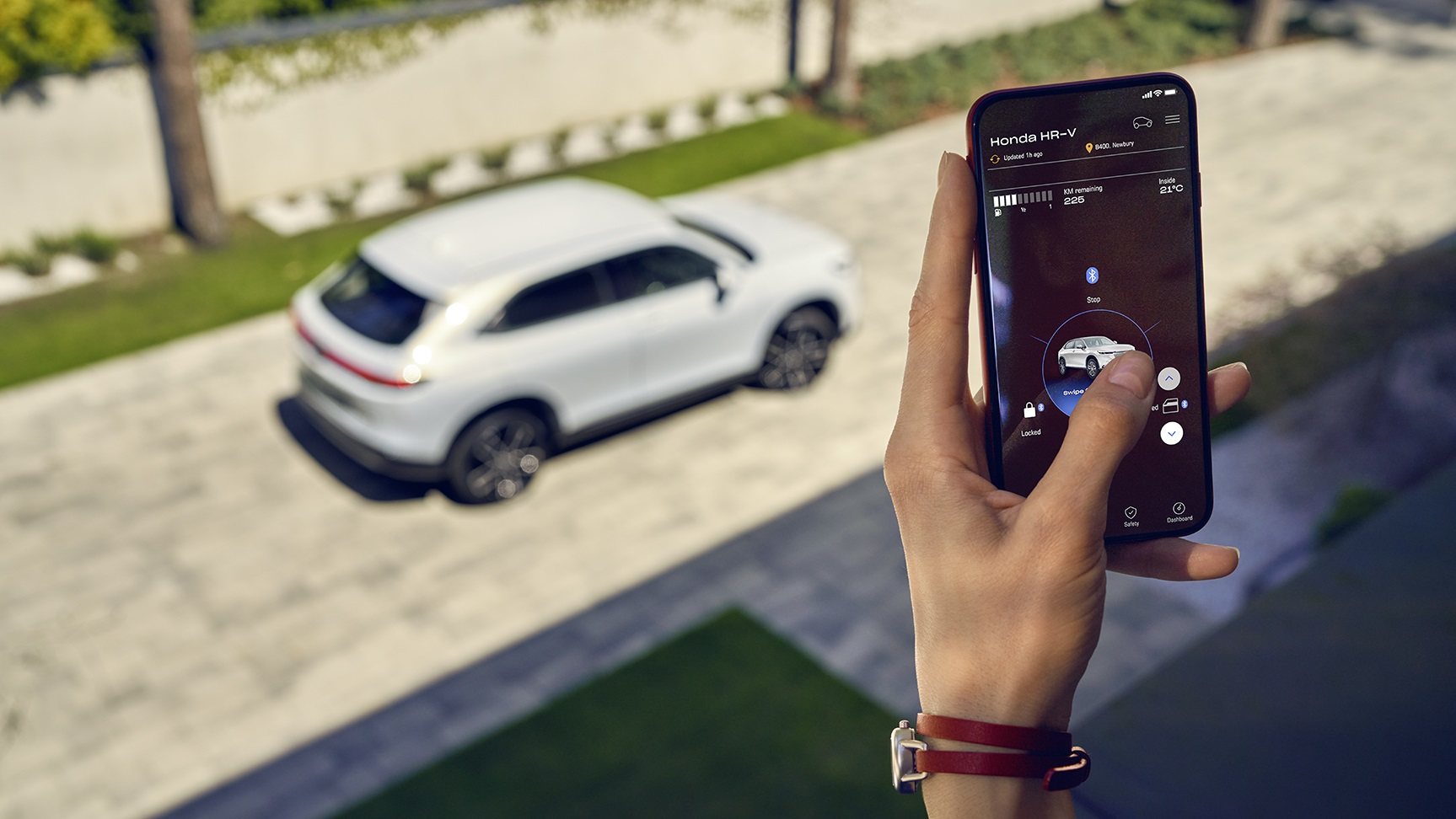 Eine Person bedient hier Auto vom Handy.