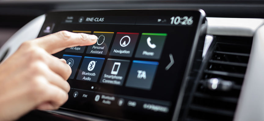 Mann verwendet My Honda Plus App mit einem Honda Jazz Hybrid Crosstar im Hintergrund 