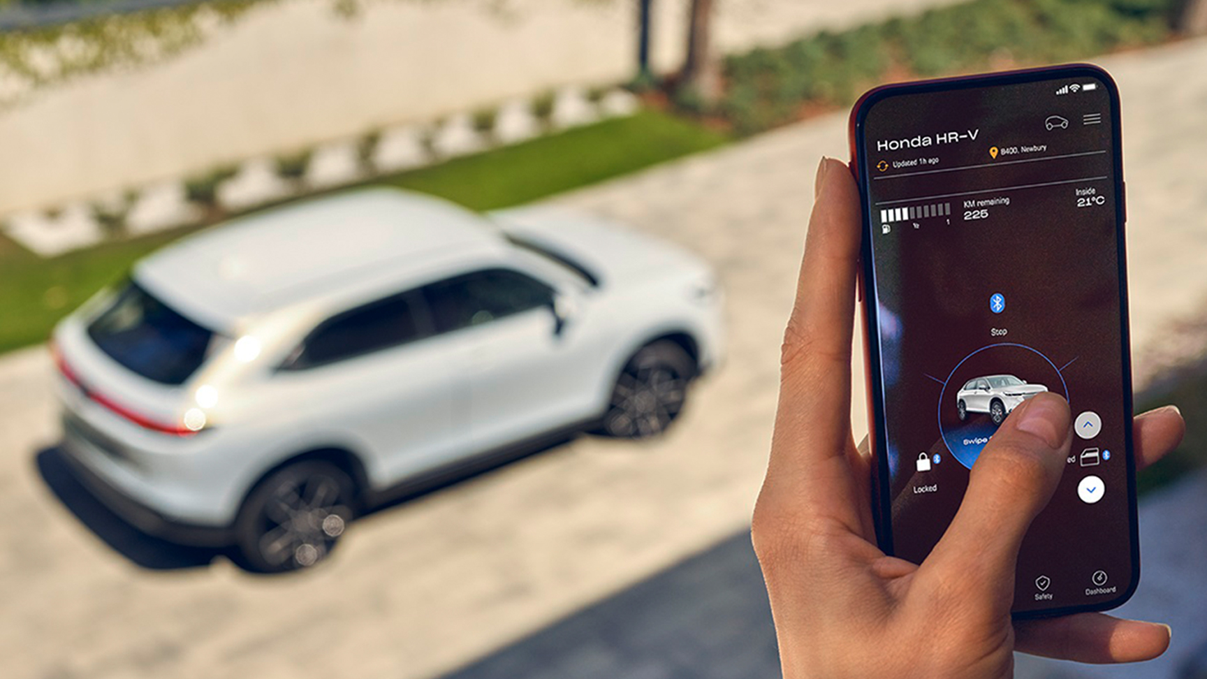 Nahaufnahme einer Frau mit einem digitalen Schlüssel, im Hintergrund ein Honda HR-V.