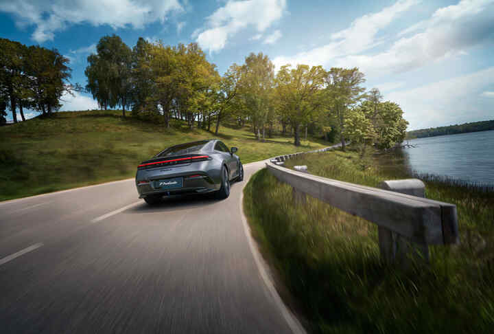 Honda Prelude auf einer malerischen Uferstraße mit Bergen im Hintergrund.