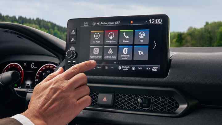 Eine Hand bewegt sich, um den Infotainment-Bildschirm des Prelude Hybrid zu berühren.
