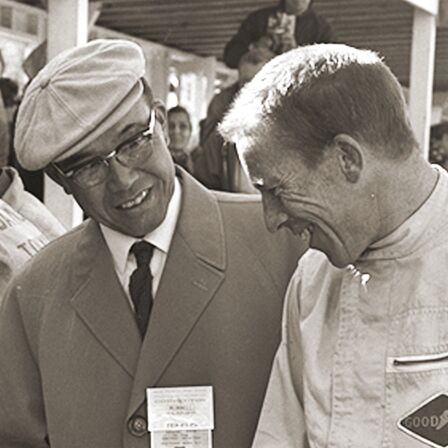 Soichiro Honda und Richie Ginther auf einer Rennstrecke.