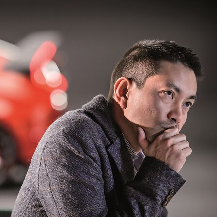 Seitenansicht eines Honda Civic mit Fließheck mit einem nachdenkenden Mann.