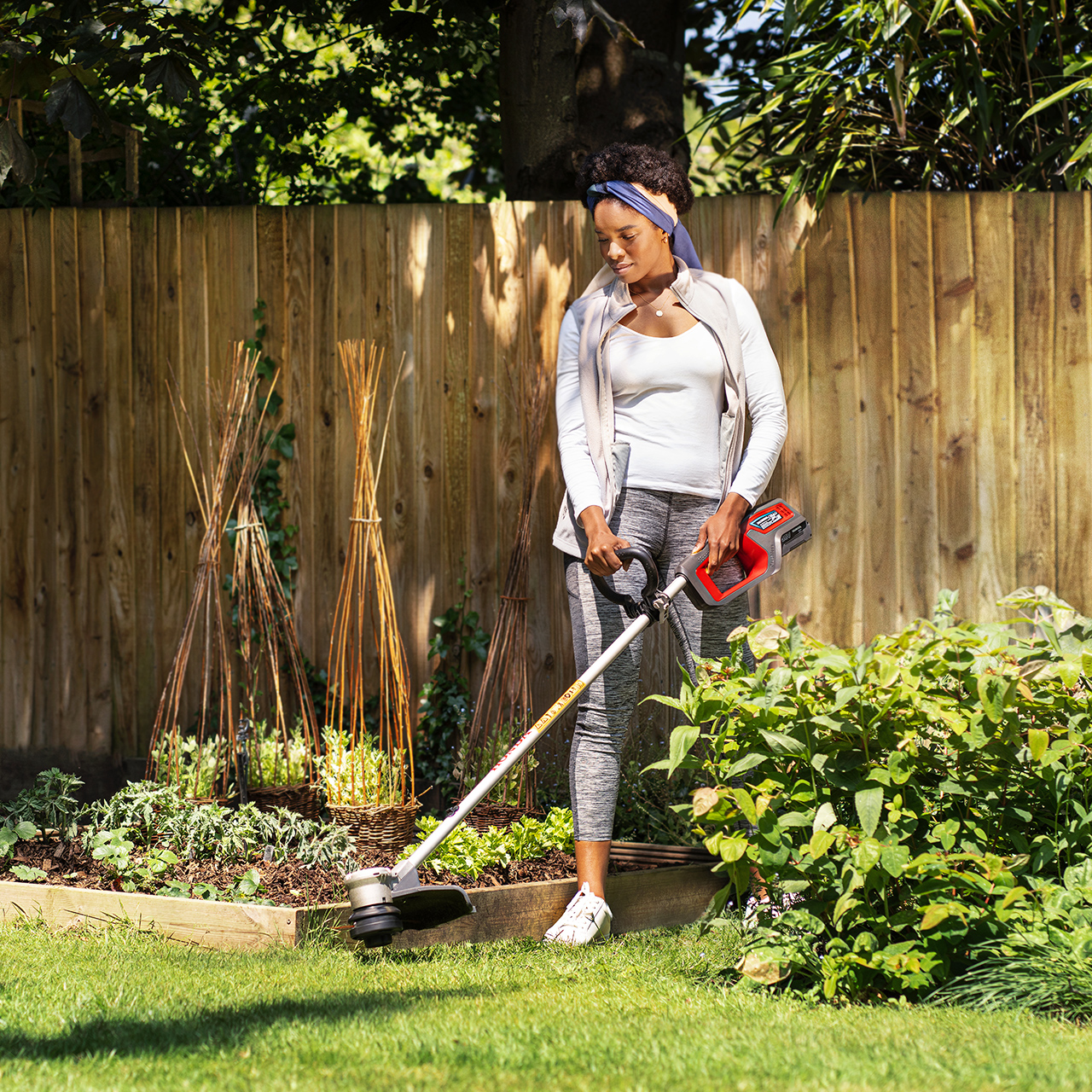 Frau bei der Verwendung eines Akku-Trimmers