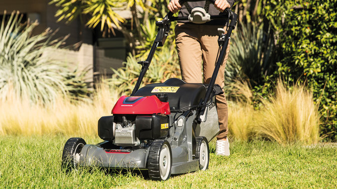 Honda HRX-Rasenmäher in einem Garten, Frontansicht.