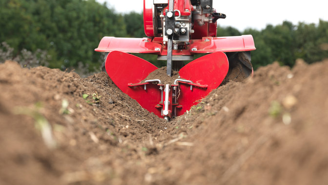 Einachsschlepper mit H&auml;ufelk&ouml;rperaufsatz, Gartenumgebung.