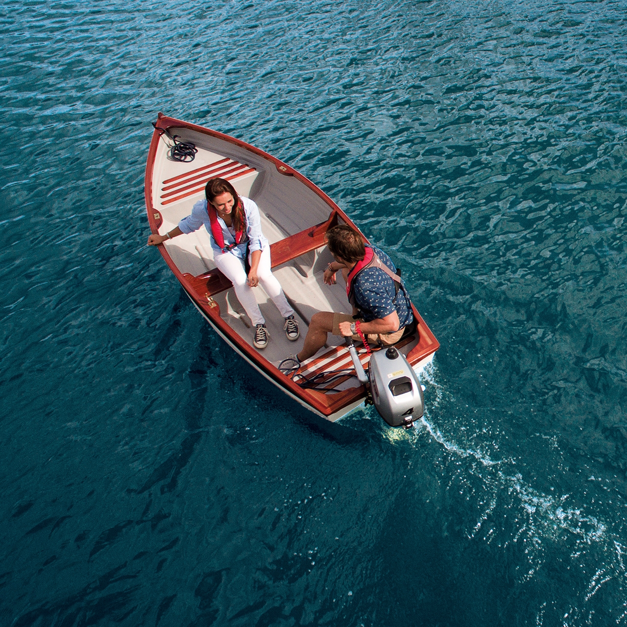 Paar auf einem Boot mit Honda Motor auf dem Wasser.
