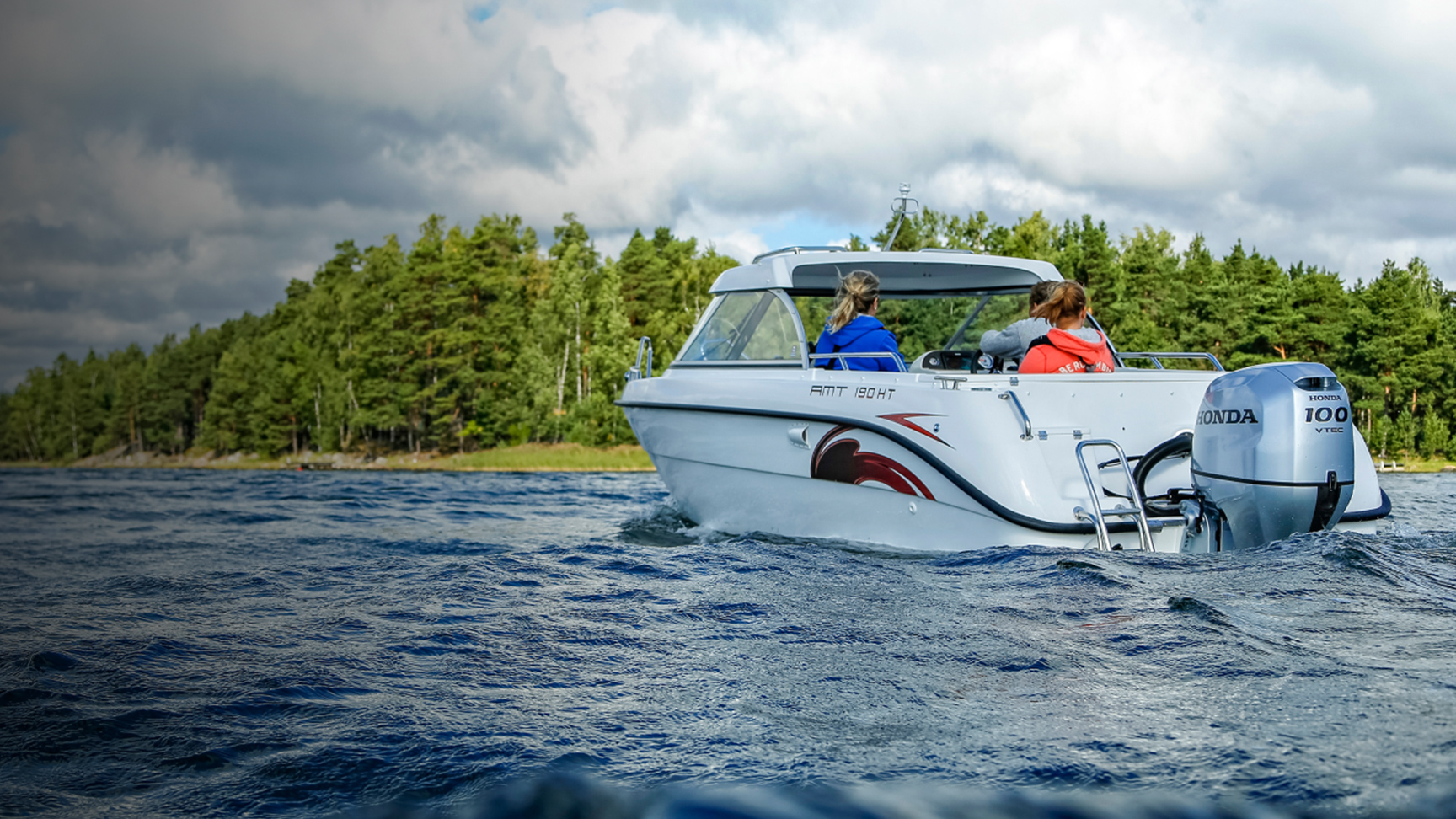 Familie auf einem Boot mit Honda BF80-100-Motor auf einem See. 
