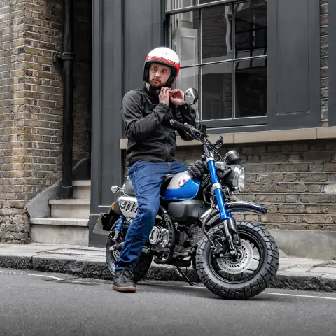 Honda Monkey 125 mit Fahrer, abgestellt am Straßenrand