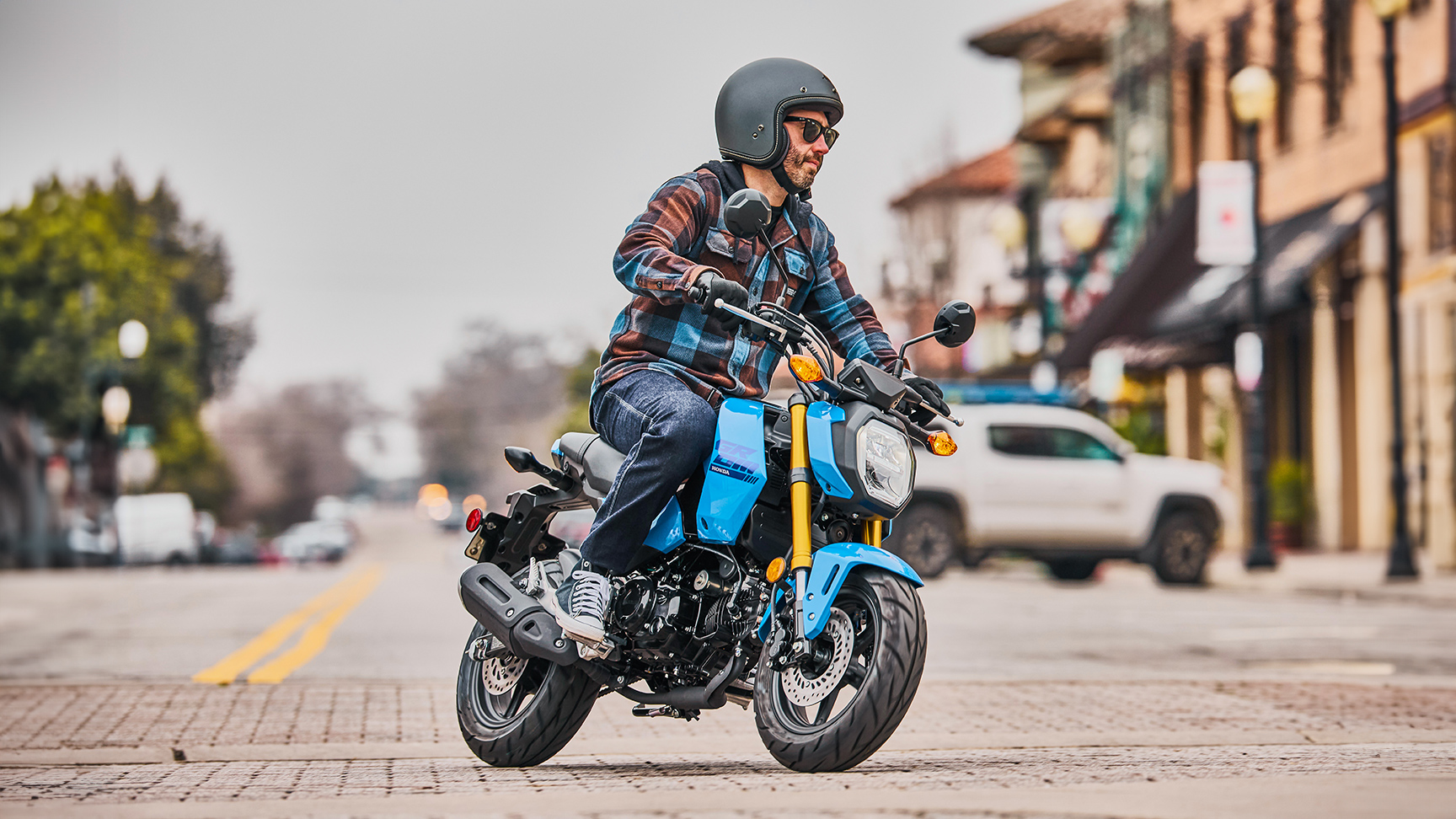 MSX125 Grom in Blau mit Fahrer, der in eine Kurve einfährt 