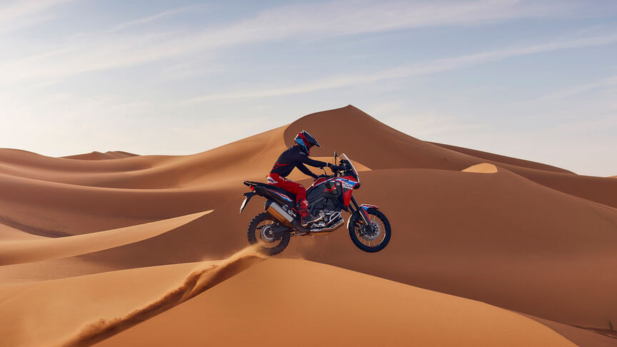 Africa Twin mit Fahrer auf einer Düne