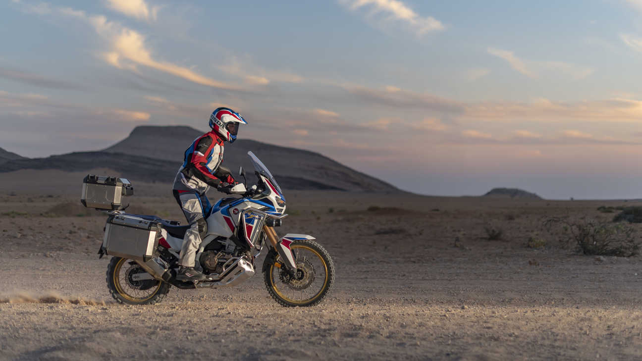 Honda Africa Twin Adventure Sports, rechte Seite, auf einem unbefestigten Weg in einer Wüstenlandschaft.