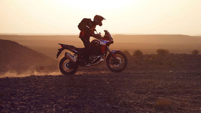 Model auf einem CRF1100L Africa Twin-Motorrad in einer Wüste.