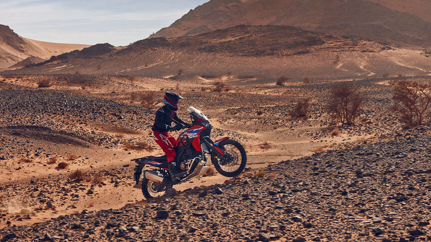 Model auf einem CRF1100L Africa Twin-Motorrad in einer Wüste.