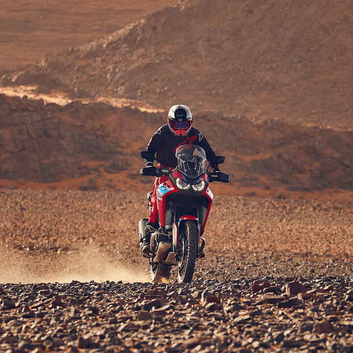 Model auf einem CRF1100L Africa Twin-Motorrad in einer Wüste.