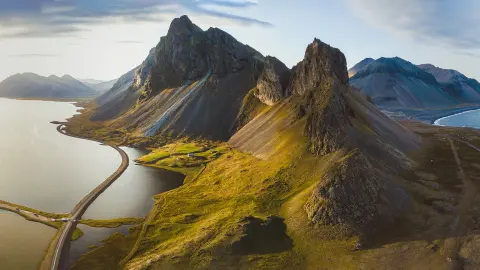 Malerische Straße in Island, wunderschöne Naturlandschaft, Luftbildpanorama, Gebirge und Küste bei Sonnenuntergang