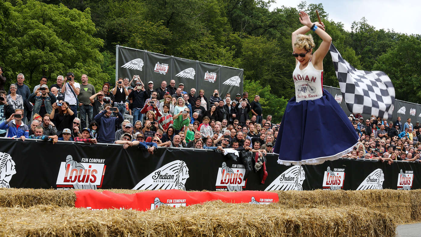 Eine Lady schwenkt die Zielflagge