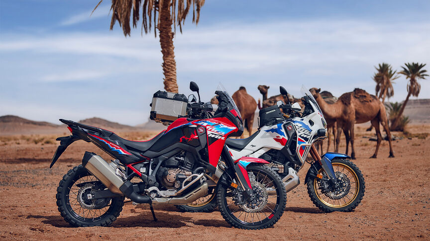 Marokkanische Landschaft mit Honda Adventure Fahrern auf der Straße.