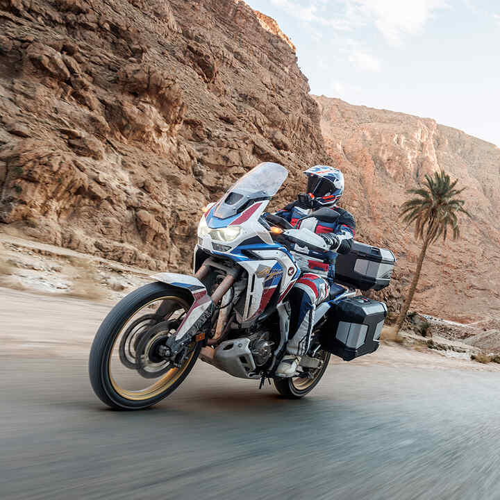 Africa Twin im Gelände mit Touring-Zubehör und Fahrer.