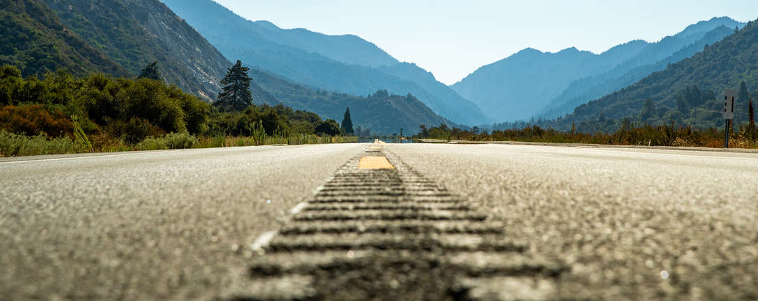 Offene Asphaltstraße vor einem Gebirge