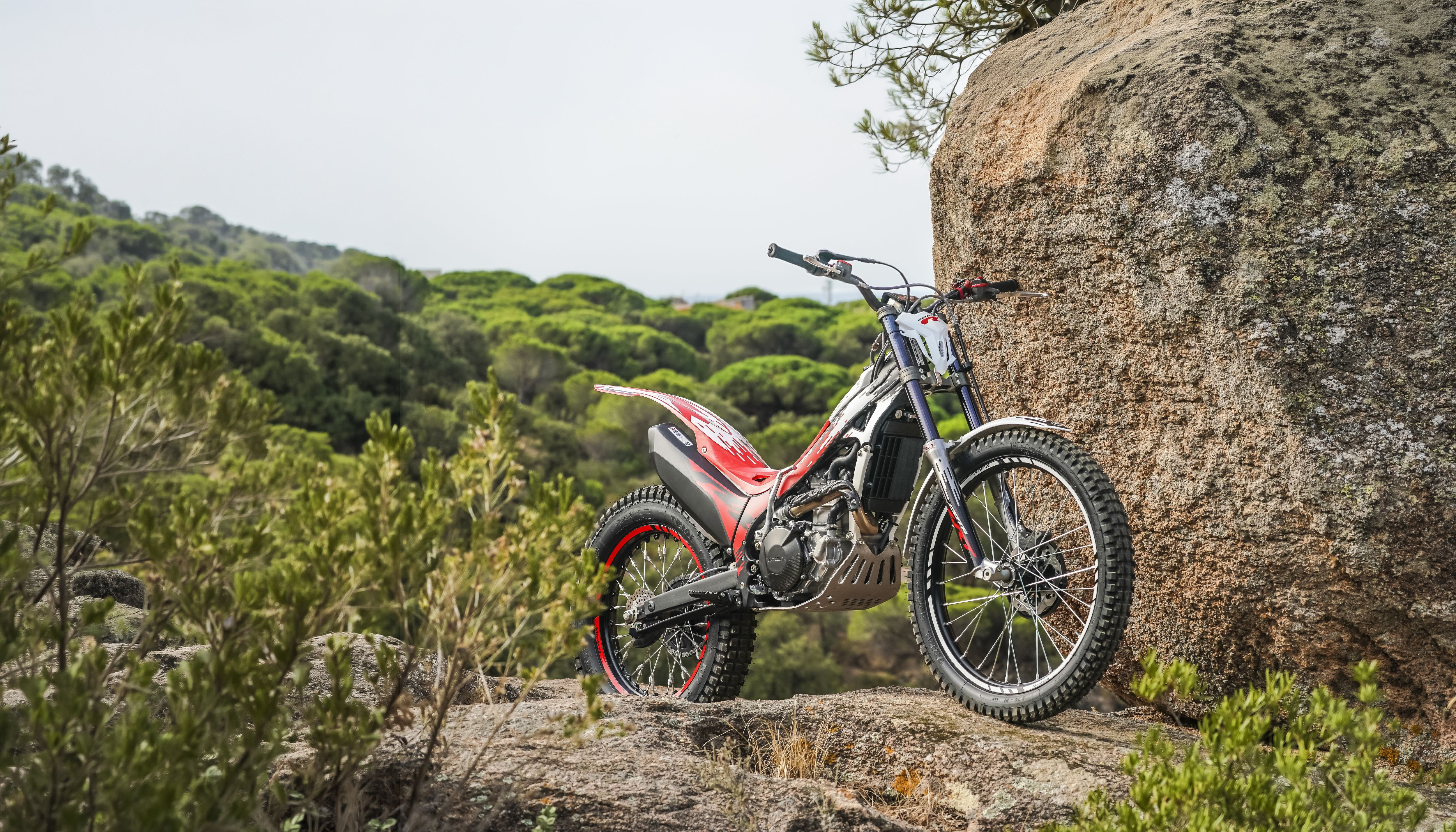 Ein Montesa Cota 301RR Trial-Motorrad auf felsigem Gelände im Freien.