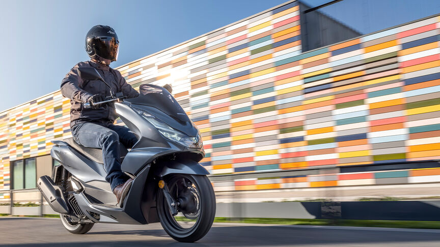 Honda PCX125 – ¾-Heckansicht in Bewegung mit Fahrer