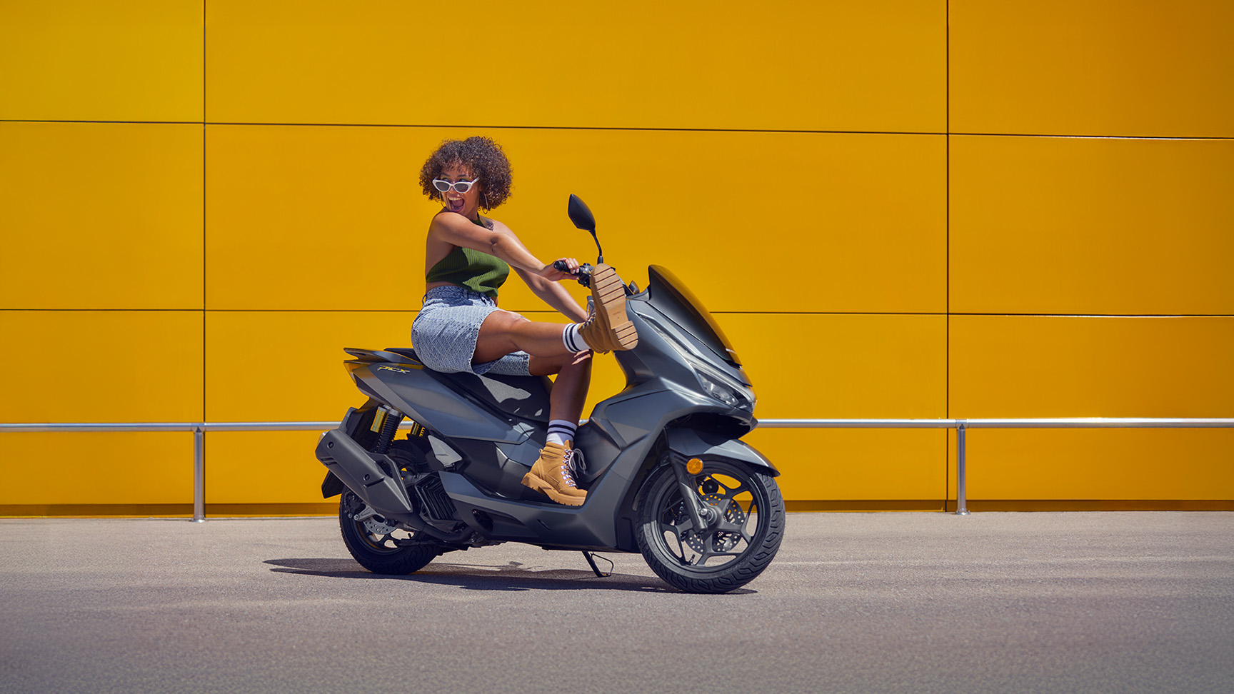 Model sitzt auf dem PCX125 Motorrad.
