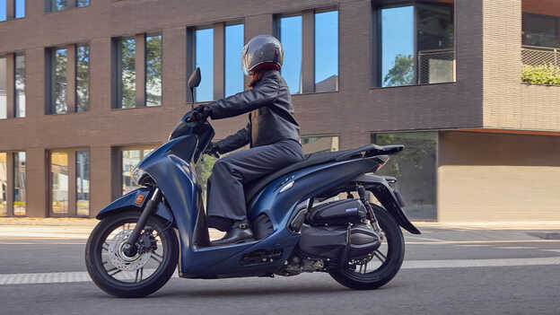 Fahrer auf dem Honda SH350i in der Stadt, Seitenansicht.