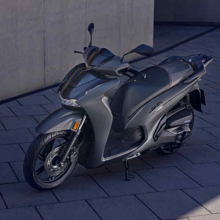 Abgestellter Honda SH350i auf einem Hof, 3/4-Frontansicht.