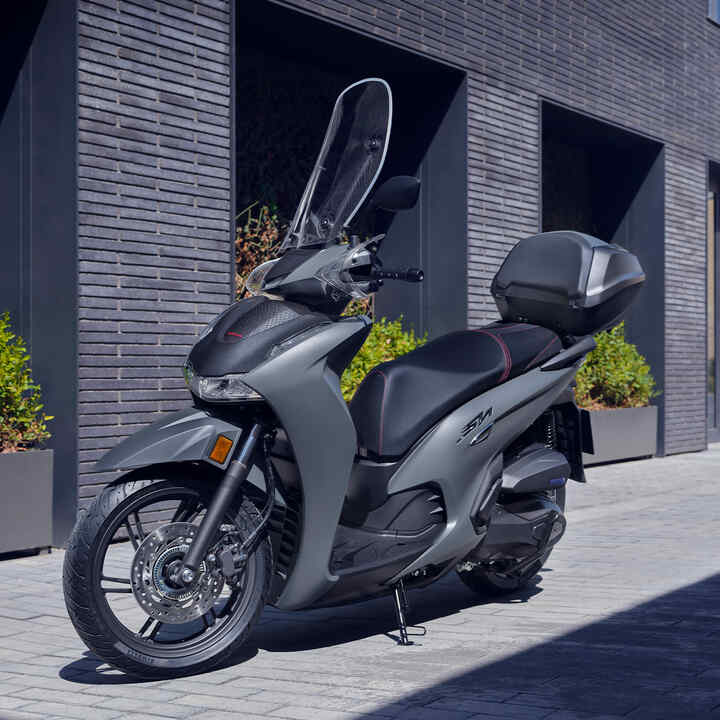 Abgestellter Honda SH350i in bebauter Umgebung, 3/4-Frontansicht.