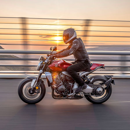 Honda CB1000R, linke Seite, mit Fahrer, auf der Straße, mit dem Sonnenaufgang