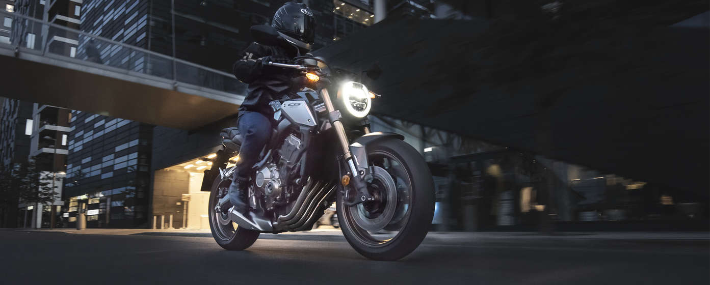 Honda CB650R in Fahrt vor einer Straßenkulisse.