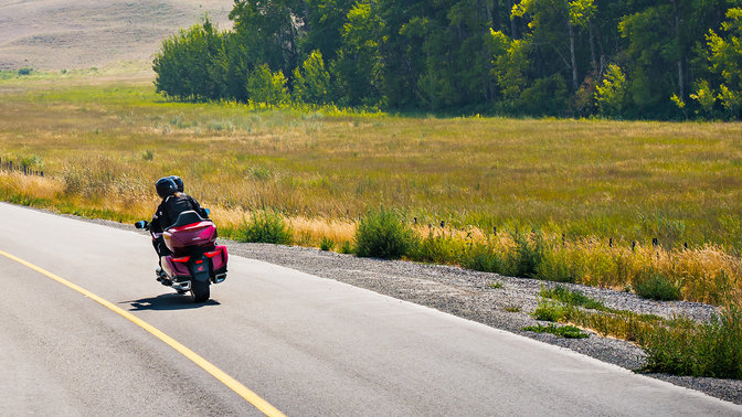 Dreiviertel-Heckansicht einer Honda Gold Wing, ländliche Umgebung.
