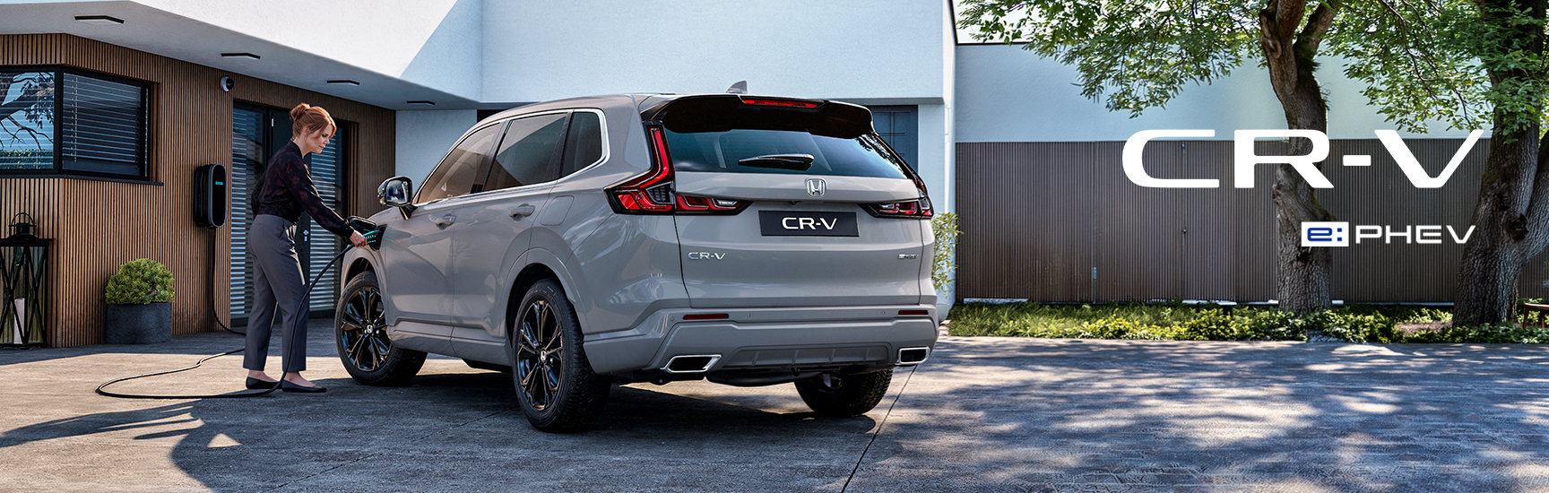 CR-V Plug-in Seitenansicht parkt vor Gebäuden
