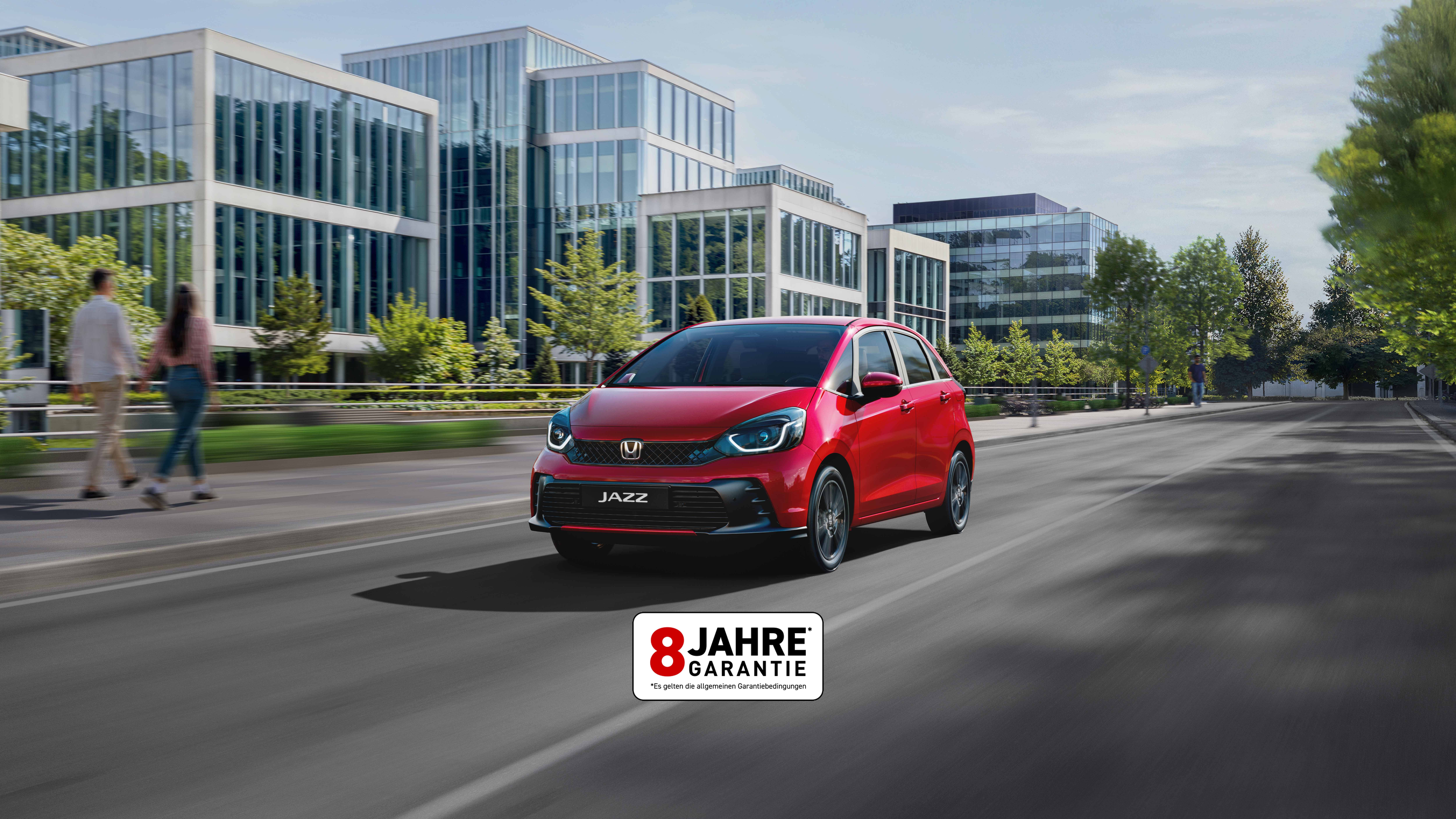 Honda Jazz fährt eine Straße in einer Stadt entlang.