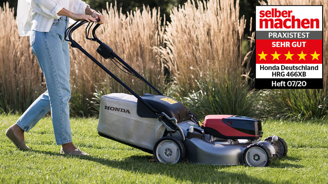 Model demonstrating Honda izy-On lawnmower in garden location.