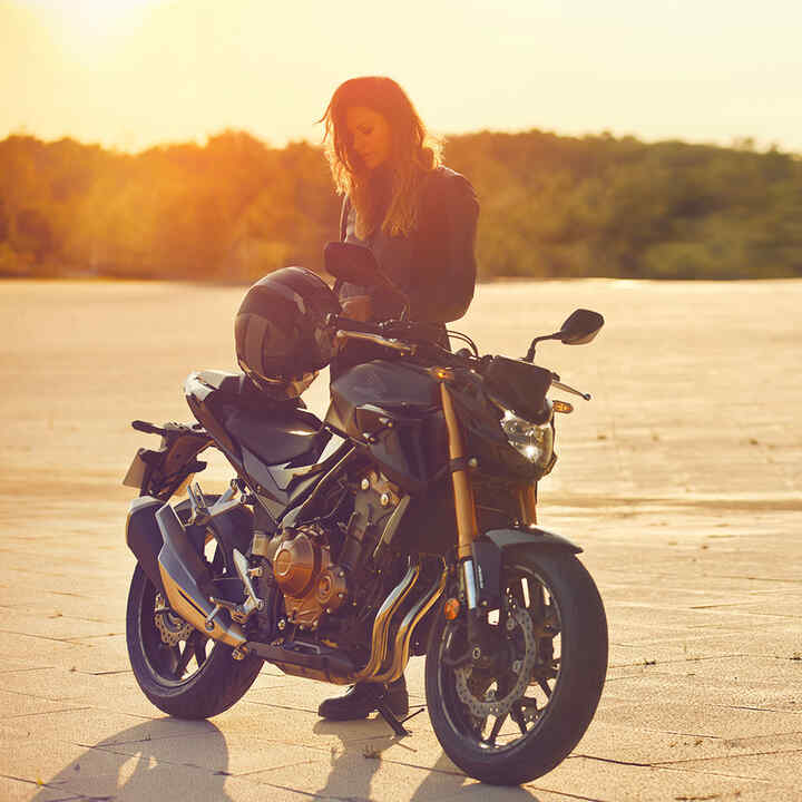 Frau steht hinter Honda Motorrad 