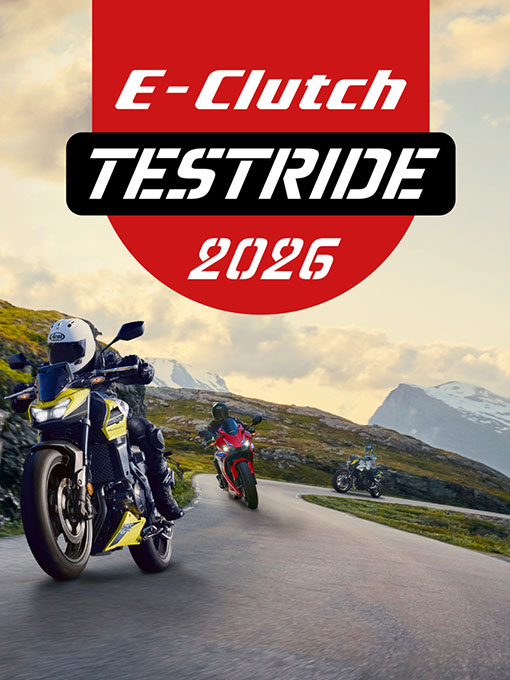 Drei Honda-Motorräder fahren auf einer Bergstraße. Das Bild zeigt im Vordergrund ein Adventure-Bike, gefolgt von einem Sportbike und einem Straßenmotorrad. Der Text „E-Clutch TESTRIDE 2026” ist vor einem rot-weißen Hintergrund eingeblendet.
