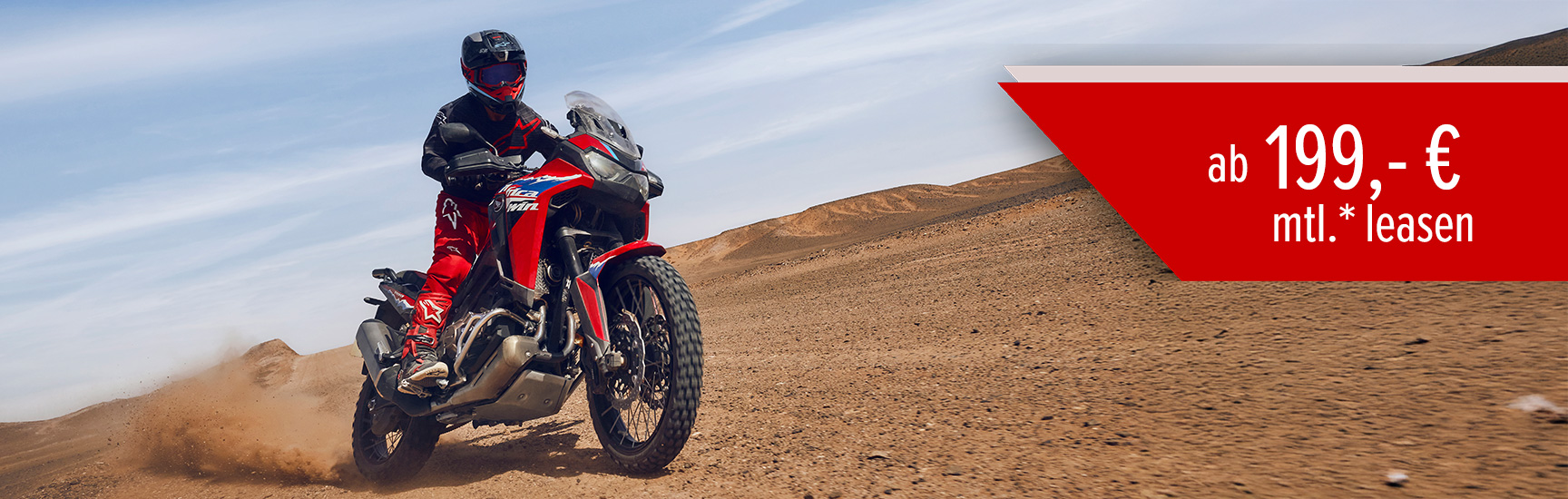 Ein Mann fährt auf einer Honda CRF1100L AFRICA TWIN durch eine Wüste.
